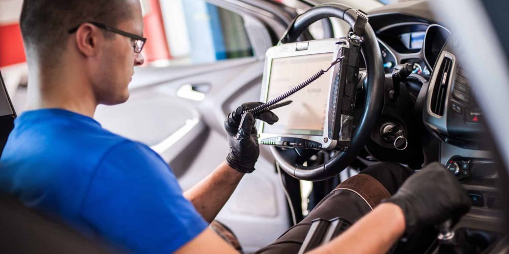 Technician running a camera calibration from a tablet inside a car